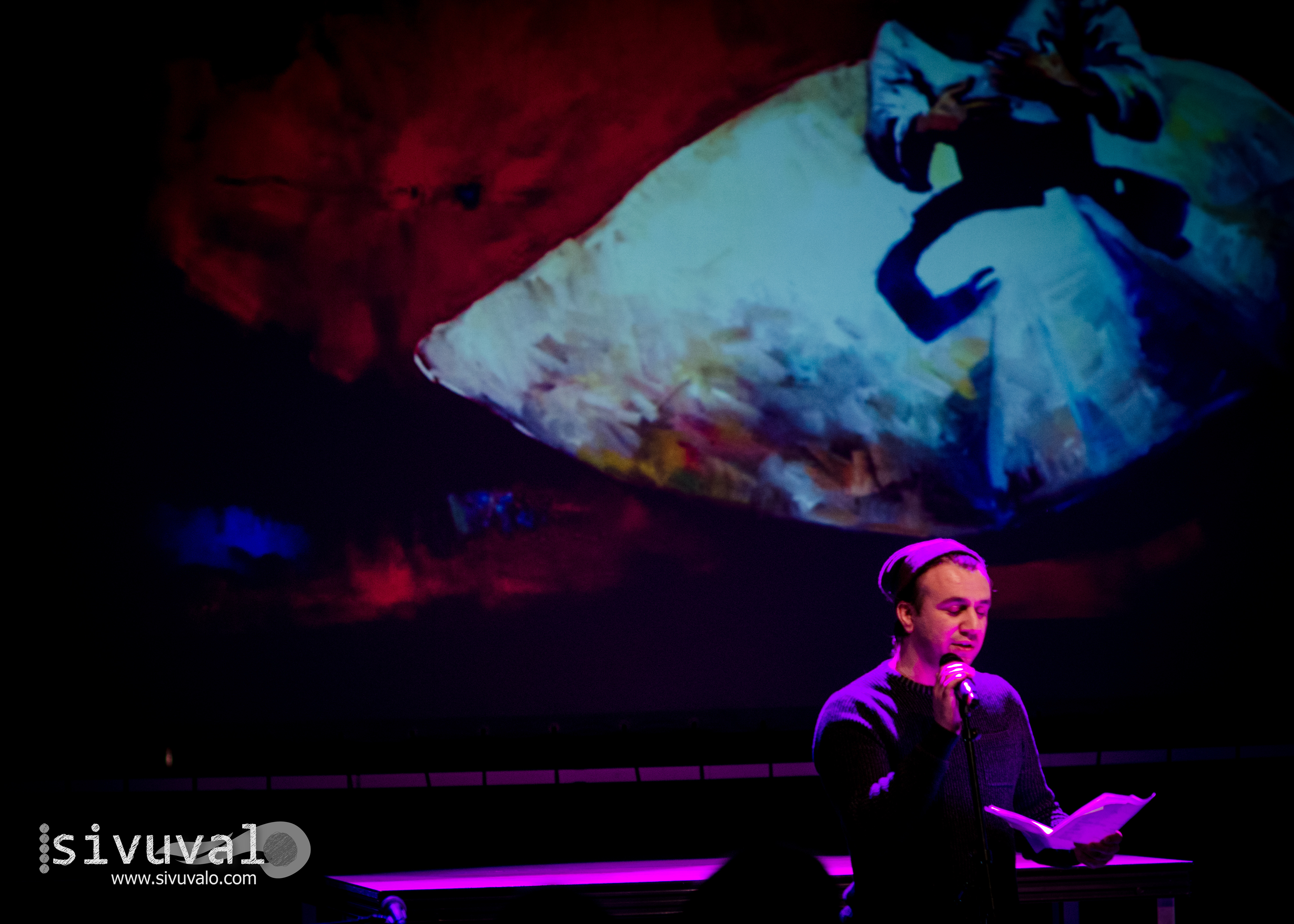 Iraqi visual artist and poet Muhaned Durubi with one of his paintings behind [Photo by: Jaime Culebro]